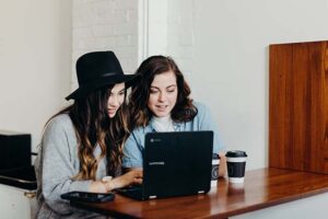 Lesbian couple looking at their laptop together representing a couple looking for premarital counseling in Austin, TX. 