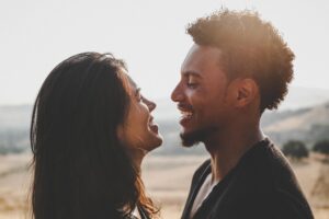 Happy couple facing each other smiling representing a couple who have grown closer and strengthened their relationship with Premarital Counseling in Austin, TX.