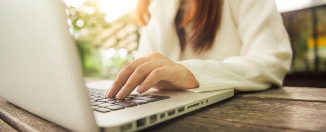 Woman working on her laptop participating in online therapy for anxiety in San Antonio, TX.