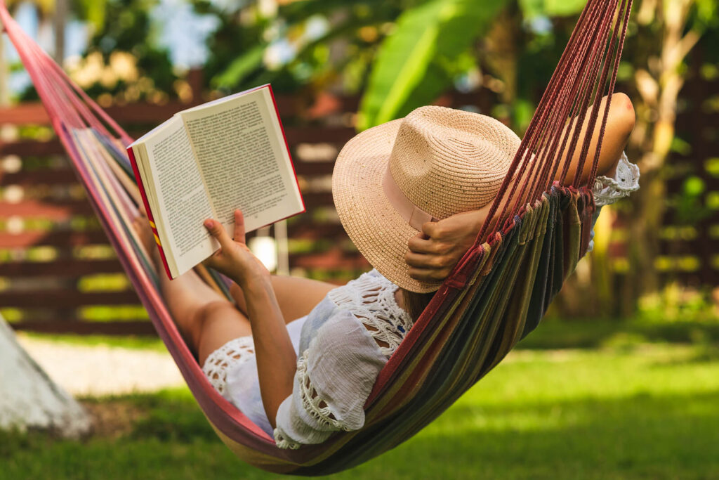 Woman lying in a hammock reading a book practicing self-care to combat her anxiety. You too can learn the skills to overcome anxiety with Therapy for Anxiety in San Antonio, TX.