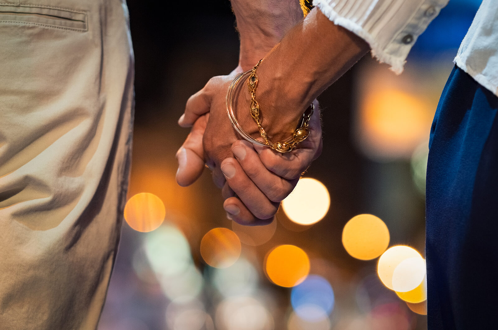 Couple walking at night with their hands clasped representing the deepened connection that can be formed with the help of Couples Counseling in San Antonio, TX.