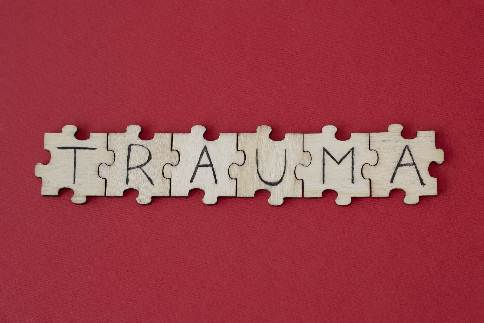 Wooden tiles spelling out Trauma on a red background. Trauma does not have to control your life. Therapy for Trauma in San Antonio, TX can help you find peace.