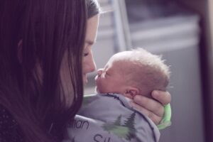 Woman kissing her newborn baby, postpartum. San Antonio, Tx. Online Counseling, Virtual Counseling. 78249, 78255, 78258, 78230, 78248.