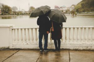 Couple talking in the rain, while holding hands, closely together. Modern Wellness Counseling. San Antonio, Tx. 78230,78249,78250,78255,78258.