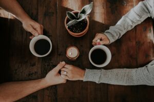 Couple reconnecting, holding hands in coffee shop building physical intimacy in San Antonio, Texas. 78249, 78229, 78256, 78257, 78759, 78727, 77005, 75225